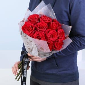 Bouquet with 15 red roses wrapped in heart-print paper and premium ribbon.