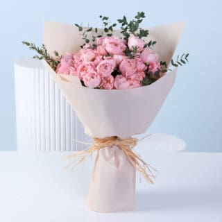 Blush pink garden roses with greenery in nude wrapping, finished with ribbon detailing.