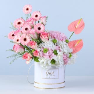 BTF Home 40 A soft pastel floral arrangement with layered blooms and fresh green accents, beautifully styled in a round white box.