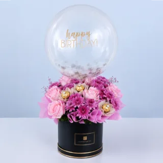 BTF Home 75 Pink-themed bouquet in a black round box featuring roses, chrysanthemums, Ferrero Rocher chocolates, and a balloon arranged as a luxurious celebration gift.