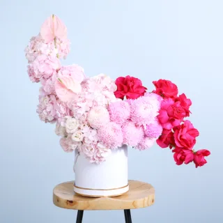 Floral Grandeur Hat Box featuring dark pink roses, light pink hydrangeas, lisianthus, and elegant pink blooms beautifully arranged in a premium hat box.