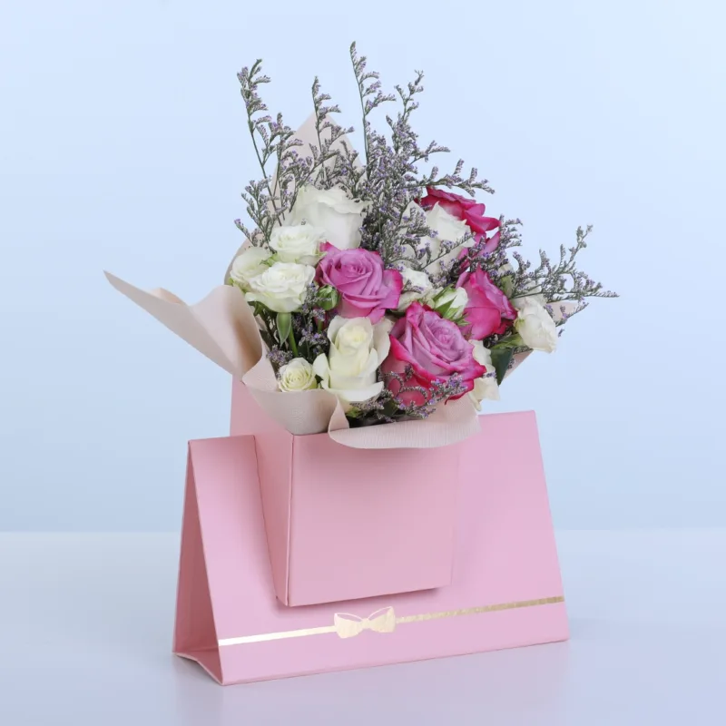 purple-white-rose-pink-envelope-box Purple & White Rose Pink Envelope Box featuring 5 purple roses, 5 white roses, 3 spray roses, and delicate caspia arranged in a premium pink envelope-style flower box.