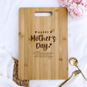 Cutting Board light brown wooden cutting board with rounded corners and a handle cutout at the top is positioned on a wrinkled white cloth.