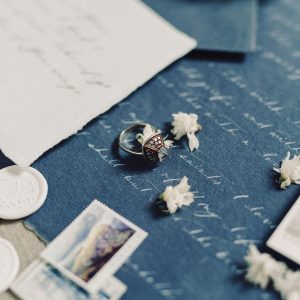 Handwritten Jewellery This is a close-up shot of various stationery items and a ring, possibly arranged for a wedding or romantic theme