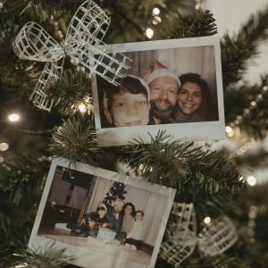 Photo Gift two Polaroid photos. The first Polaroid appears to show three individuals, possibly a family, with one wearing a Santa hat